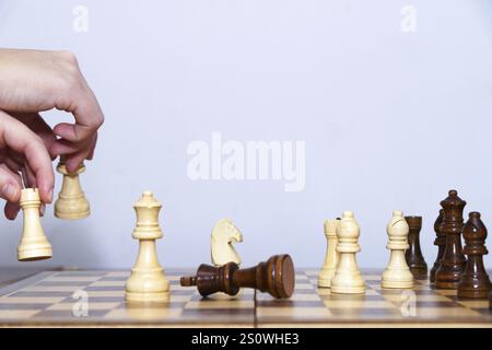 Nahaufnahme der Hände einer Frau, die Schach spielt, mit weißem Hintergrund und Kopierraum Stockfoto