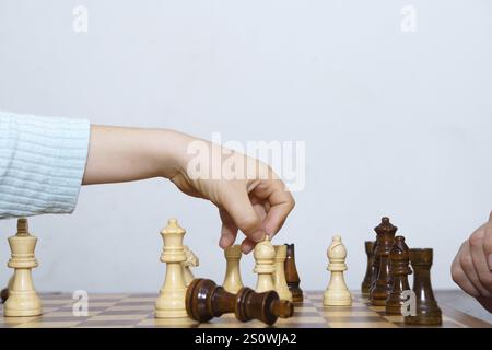 Nahaufnahme der Hände eines Kindes, die Schach spielen, mit weißem Hintergrund und Kopierraum Stockfoto