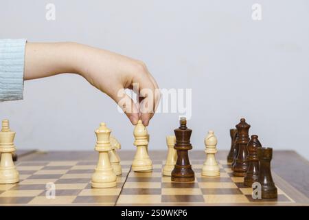Nahaufnahme der Hände eines Kindes, die Schach spielen, mit weißem Hintergrund und Kopierraum Stockfoto