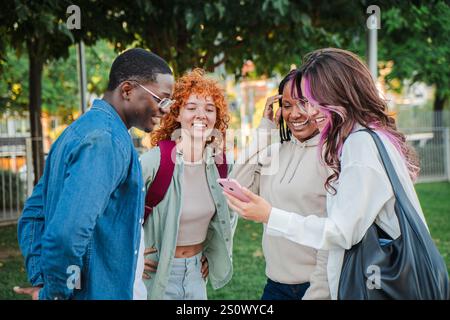 Eine Gruppe multirassischer Teenager-Studenten, die sich im Freien unterhalten und lachen, Freundschaft und Bindungsmomente in einem lebendigen, Jugendlichen und fröhlichen Ausdruck auf dem Universitätscampus genießen. Freunde, die Spaß haben. Hochwertige Fotos Stockfoto