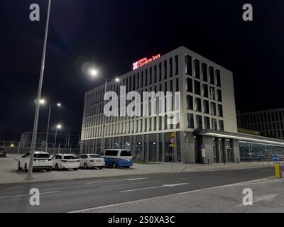 KRAKAU, POLEN - 27. OKTOBER 2024: Gebäude des Hilton Garden Inn Hotels am Flughafen Krakau-Balice, Polen bei Nacht Stockfoto