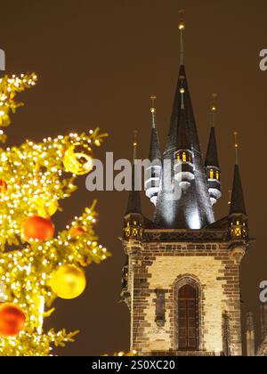 Gotischer Kirchturm beleuchtet bei Nacht mit festlichen Weihnachtsbaumlichtern im Vordergrund. Die Kirche unserer Lieben Frau, Prag Stockfoto