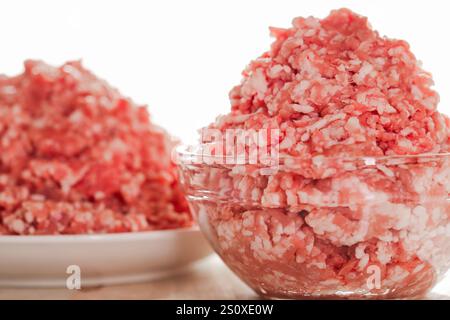 Hackfleisch in Schüsseln. Hackfleisch in einem Glasbecher auf weißem Hintergrund. Frisches Bioprodukt. Hackfleisch in einer Schüssel. Stockfoto