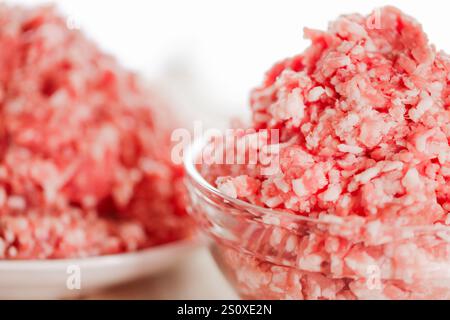 Hackfleisch in einem Glasbecher auf weißem Hintergrund. Frisches Bioprodukt. Hackfleisch in einer Schüssel. Stockfoto