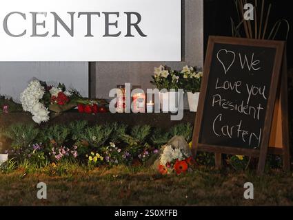 New York, Usa. Dezember 2024. Blumen, andere Waren und Schilder werden am Haupteingang des Carter Center in Atlanta, GA, nach dem Tod des ehemaligen Präsidenten der Vereinigten Staaten Jimmy Carter am Sonntag, den 29. Dezember 2024, hinterlassen. Jimmy Carter, 39. Präsident der Vereinigten Staaten und Friedensnobelpreisträger 2002, starb friedlich am Sonntag in seinem Haus in Plains, Georgia. Mit 100 Jahren war er der am längsten gelebte Präsident in der Geschichte der USA. Foto von Mike Zarrilli/UPI Credit: UPI/Alamy Live News Stockfoto