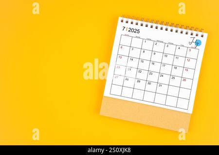 Tischkalender Juli 2025 auf gelbem Hintergrund, Position mit Kopierraum. Stockfoto