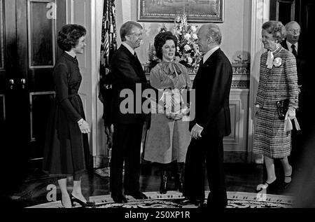 US-Präsident Jimmy Carter, links in der Mitte, begrüßt Botschafter Jacques Kosciusco-Morizet von Frankreich, rechts in der Mitte, im Blauen Raum des Weißen Hauses in Washington, DC, am ersten vollen Tag der Carter-Mondale-Administration am 21. Januar 1977. Im Zentrum steht der Protokollchef der US Shirley Temple Black. First Lady Rosalynn Carter steht links und Madame Morizet rechts. Kredit: Barry A. Soorenko/CNP Stockfoto