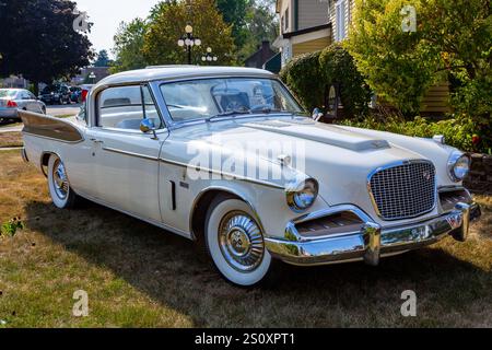 Ein weißes und goldenes Studebaker Golden Hawk Coupé aus dem Jahr 1957, das im Gras in Auburn, Indiana, USA, geparkt wird. Stockfoto