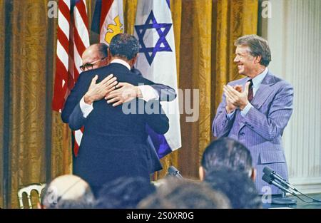 US-Präsident Jimmy Carter, rechts, applaudiert als Präsident Anwar Sadat von Ägypten, Mitte, und Premierminister Menahem Begin of Israel, links, umarmen während der Unterzeichnungszeremonie für das Camp David Abkommen im östlichen Raum des Weißen Hauses am 17. September 1978.Credit: Arnie Sachs/CNP Stockfoto