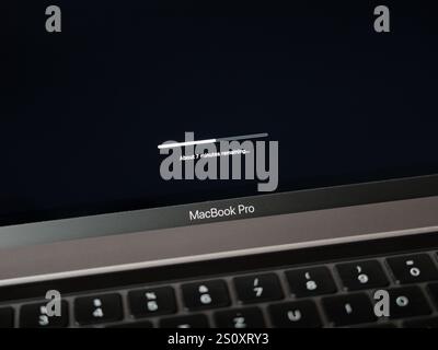 Apple MacBook Pro Installieren eines Updates. Fortschrittsanzeige wird während der Aktualisierung auf dem schwarzen Bildschirm geladen und zeigt die verbleibende Zeit an. Stockfoto