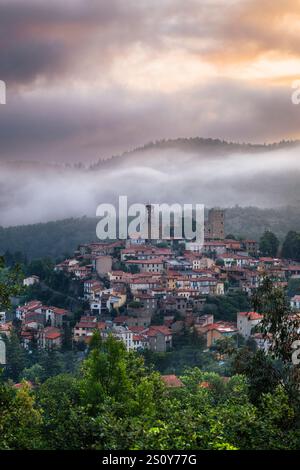 Wolken und Nebel über der Altstadt von Vernet-les-Bains vor den Bergen der französischen Pyrenäen bei Sonnenaufgang, Okzitanien, Frankreich Stockfoto