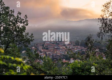 Wolken und Nebel über der Altstadt von Vernet-les-Bains vor den Bergen der französischen Pyrenäen bei Sonnenaufgang, Okzitanien, Frankreich Stockfoto
