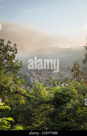 Wolken und Nebel über der Altstadt von Vernet-les-Bains vor den Bergen der französischen Pyrenäen bei Sonnenaufgang, Okzitanien, Frankreich Stockfoto