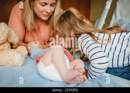 Mom und Mädchen küssen im Krankenhaus den neugeborenen Bruder Stockfoto