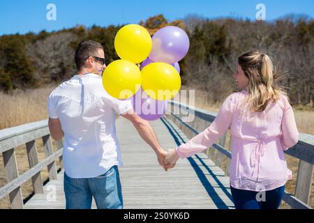 Bald werden Eltern auf der Brücke laufen und Hände halten, die sie anschauen Stockfoto