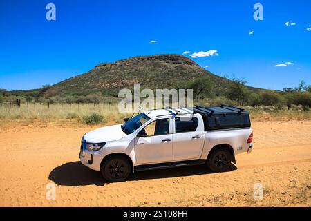 Geländefahrten mit einem Mietwagen auf einer Schotterstraße, einem Geländewagen in einer sandigen Wüstenlandschaft in Namibia. Toyota Hilux SUV 4x4 Geländefahrzeug. März 20 Stockfoto