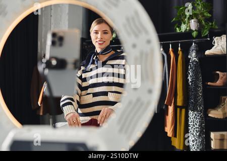 Die junge Stylistin zeigt ihre neuesten Mode-Looks, während sie auf ihrem Smartphone aufnimmt. Stockfoto