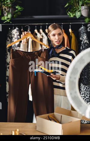 Fashion Influencer präsentiert stilvolle Outfits und lebendige Schuhe, während er in einem schicken Studio Vloggen kann. Stockfoto