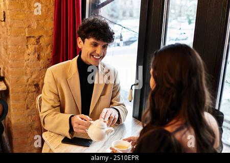 Ein junges Paar teilt einen freudigen Moment bei einem Tee, während es am Valentinstag seine Liebe feiert. Stockfoto