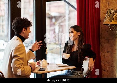 Um die Liebe zu feiern, teilt ein Paar ein Lächeln und warme Momente bei einem Kaffee in einer intimen Umgebung. Stockfoto