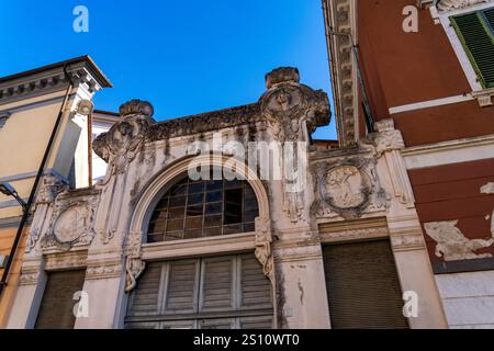 Das kunstvoll geschnitzte Marmortor einer ehemaligen Residenz auf der Piazza Fabrizio de Andre in Carrara, Italien. Stockfoto
