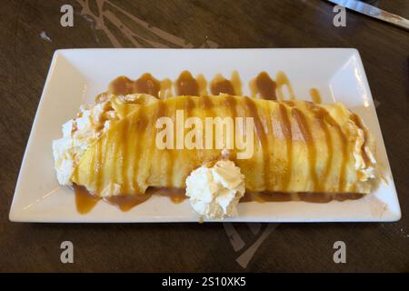 Ein süßer Krepp mit Schlagsahne, Schokolade und Karamellsauce. Stockfoto