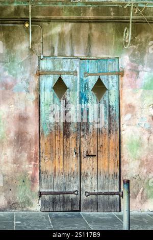 Alte verrottete Holztüren mit abblätternder Farbe im historischen Viertel des French Quarter in New Orleans, die ältere Zeiten symbolisieren Stockfoto