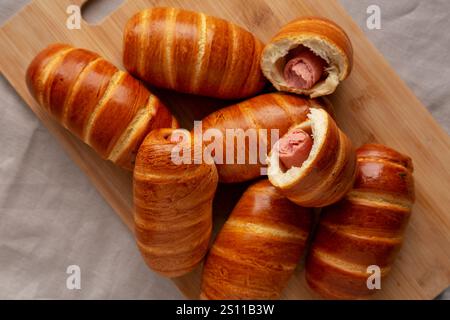 Hausgemachte Wurstbrötchen auf einem Bambusbrett, Blick von oben. Flache Lage, über Kopf, von oben. Stockfoto