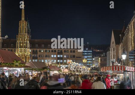 Christkindlesmarkt in weihnachtlicher Beleuchtung am Abend, links der schöne Brunnen, Hauptmarkt, Nürnberg, Mittelfranken, Bayern, Ge Stockfoto