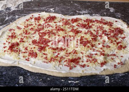 Schwäbische Küche, Zubereitung von herzhaftem Hefegeflecht mit Räucherfleisch, salziges Kranzbrot, Hefeteig Teig, roher Hefeteig mit Käse, sauer Stockfoto