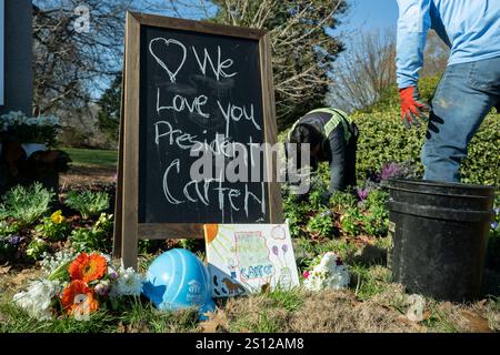 Atlanta, Georgia, USA. Dezember 2024 30. Gärtner Pflanzen Blumen vor dem Jimmy Carter Presidential Library and Museum Schild. Das Carter Center gibt eine Erklärung heraus, in der die Familie eine Einladung des Kongresses für Carter, der Sonntag um 100 Uhr starb, angenommen hat, in der Capitol Rotunde zu liegen. (Kreditbild: © Christopher Oquendo/ZUMA Press Wire) NUR REDAKTIONELLE VERWENDUNG! Nicht für kommerzielle ZWECKE! Quelle: ZUMA Press, Inc./Alamy Live News Stockfoto