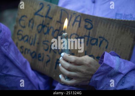 Quito, Ecuador. Dezember 2024 30. Ein Demonstrant hält während der Demonstration ein Plakat und eine zündete Kerze. Der Regen ist gekommen und 22 Tage sind vergangen, seit die vier Kinder aus Las Malvinas in Guayaquil verschwunden sind. Dutzende von Menschen gehen weiterhin auf die Straße, um friedlich zu demonstrieren und fordern den Staat auf, sie lebend zurückzubringen. Quelle: SOPA Images Limited/Alamy Live News Stockfoto