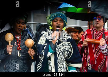 Quito, Ecuador. Dezember 2024 30. Eine schwarze Frau singt während der Demonstration. Der Regen ist gekommen und 22 Tage sind vergangen, seit die vier Kinder aus Las Malvinas in Guayaquil verschwunden sind. Dutzende von Menschen gehen weiterhin auf die Straße, um friedlich zu demonstrieren und fordern den Staat auf, sie lebend zurückzubringen. Die Verwandten der Kinder Steven Medina, Saul Arboleda und die Brüder Ismael und Josue Arroyo, die am 8. Dezember im Süden von Guayaquil verschwanden, warten immer noch auf die Bestätigung der Identität der vier verbrannten Leichen, die in einem Fluss nahe dem Luftwaffenstützpunkt Taura gefunden wurden. Gutschrift: Stockfoto