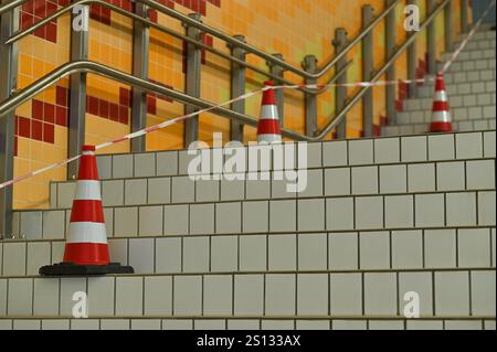 Die Treppe ist mit Keramikfliesen ausgekleidet und mit Kegeln mit Klebeband umzäunt. Stockfoto