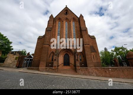 Das Gebäude der Barony Hall, auch bekannt als Barony Victorian Gothic Church in der Castle Street in Glasgow, hinter Bäumen Stockfoto