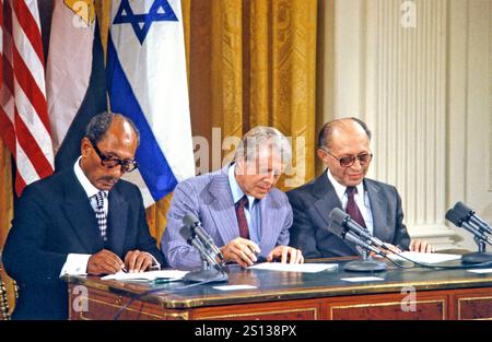 Präsident Anwar al-Sadat von Ägypten, links, US-Präsident Jimmy Carter, Mitte, und Premierminister Menahem Begin von Israel, rechts, unterzeichnen das Camp David Accords bei einer Zeremonie im East Room des Weißen Hauses in Washington, D.C. am 17. September 1978 Stockfoto