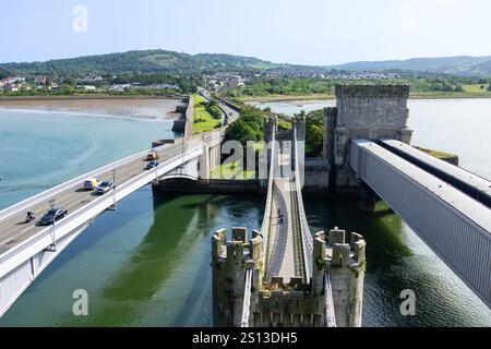 Conwy Wales - July 31 2024; Suspension bridge, tubular railway bridge, and  road bridge parallel running from Conwy castle. Stockfoto