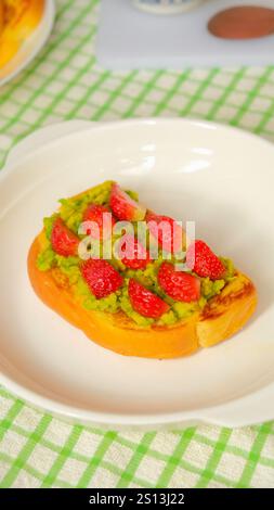 Gesunde Toasts zum Frühstück mit Avocado und Erdbeere. Stockfoto