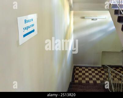 Das Schild 'Eingang zum Tierheim' auf der Treppe zum Keller des Hauses. Übersetzung des Schildes „Eingang zum Schutzhaus“ Stockfoto