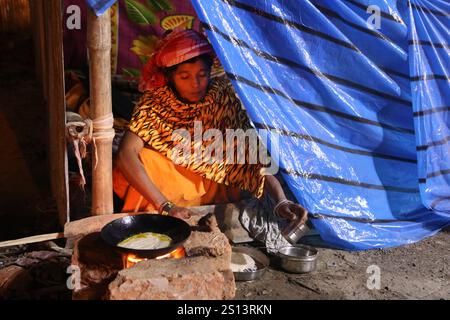 Kalkutta, Indien. Dezember 2024 30. Eine Inderin Sadhu (Hinduheilige Frau) kocht und bereitet das Abendessen in ihrem temporären Lager auf dem Weg nach Gangasagar in einer kalten Winternacht in Kalkutta, Indien, am 30. Dezember 2024 zu. Tausende von Hindu-Pilgern werden am verheißungsvollen Makar Sankranti-Festtag, der am 14. Januar fällt, das jährliche heilige Bad in Gangasagar nehmen, wo der Ganges auf die Bucht von Bengalen trifft. (Foto: Debajyoti Chakraborty/NurPhoto) Credit: NurPhoto SRL/Alamy Live News Stockfoto