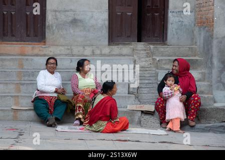 kathmandu, Nepal, 9. März 2020: Nepalesische Frauen und ein Kind sitzen auf den Stufen eines Tempels in kathmandu, nepal, und genießen einen Moment der Ruhe und Entspannung Stockfoto