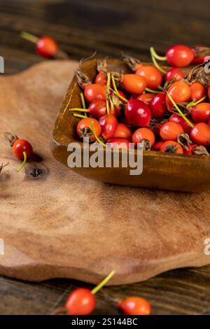 Gruppe von roten Hagebuttenfrüchten auf einem Tisch, eine Ernte von frischen roten Früchten aus einer Rose, die zur Zubereitung von Tee verwendet werden Stockfoto