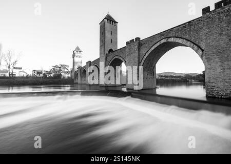 Schwarzweiß-Langzeitbelichtung des Wassers, das unter der Valentré-Brücke aus dem 14. Und 15. Jahrhundert, die zum UNESCO-Weltkulturerbe gehört, über den Riv stürzt Stockfoto