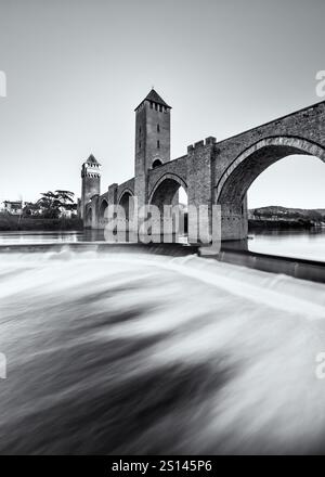 Schwarzweiß-Langzeitbelichtung des Wassers, das unter der Valentré-Brücke aus dem 14. Und 15. Jahrhundert, die zum UNESCO-Weltkulturerbe gehört, über den Riv stürzt Stockfoto