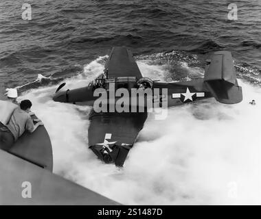 Ein Grumman TBF Avenger im Meer nach einer Trägerunglücklandung. Ein Torpedobomber aus der Zeit des Zweiten Weltkriegs, der ursprünglich für die United States Navy and Marine Corps entwickelt wurde, aber schließlich von mehreren Luft- und Marineflugzeugen auf der ganzen Welt eingesetzt wurde. Sie trat 1942 in den US-Dienst ein und wurde erstmals während der Schlacht von Midway eingesetzt. Trotz des Verlusts von fünf der sechs Avengers bei seinem Debüt überlebte er im Dienst und wurde der am weitesten verbreitete Torpedobomber des Zweiten Weltkriegs Stockfoto