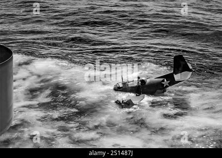 Ein Grumman TBF Avenger im Meer nach einer Trägerunglücklandung. Ein Torpedobomber aus der Zeit des Zweiten Weltkriegs, der ursprünglich für die United States Navy and Marine Corps entwickelt wurde, aber schließlich von mehreren Luft- und Marineflugzeugen auf der ganzen Welt eingesetzt wurde. Sie trat 1942 in den US-Dienst ein und wurde erstmals während der Schlacht von Midway eingesetzt. Trotz des Verlusts von fünf der sechs Avengers bei seinem Debüt überlebte er im Dienst und wurde der am weitesten verbreitete Torpedobomber des Zweiten Weltkriegs Stockfoto