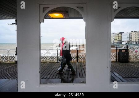 Brighton UK 31. Dezember 2024 - Wanderer trotzen dem Wind am Brighton Palace Pier, da stürmisches Wetter dazu geführt hat, dass viele Silvesterfeuerwerke im ganzen Land abgesagt wurden: Credit Simon Dack / Alamy Live News Stockfoto