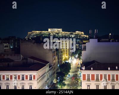 Nächtliche Stadtansicht von Athen mit beleuchteter Akropolis auf dem Hügel mit Blick auf die städtische Athena Straße. Athen, Griechenland Stockfoto