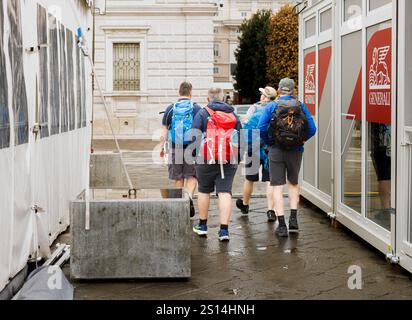 Triest, Italien - 9. Oktober 2024: Eine Gruppe von vier Wanderern mit Rucksäcken, die auf den Ständen der 56. Barcolana spazieren Stockfoto