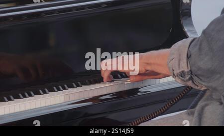 Die Hände der Pianisten kreieren auf einem wunderschönen Flügel fesselnde Melodien, die Kunstfertigkeit zeigen. Clip Stockfoto